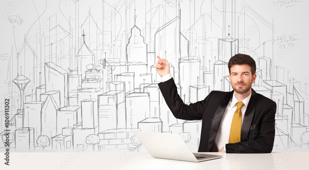 Businessman sitting at the white table with hand drawn buildings Businessman sitting at the white table with hand drawn buildings