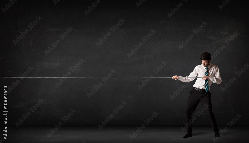 Businessman pulling rope on grey background Businessman pulling rope on grey background
