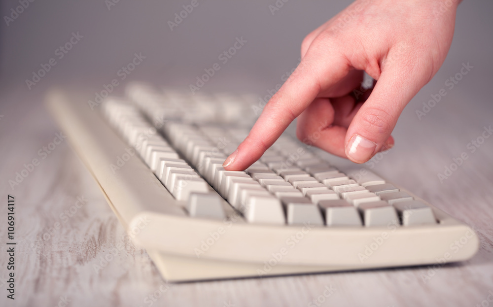 Close up of hand pressing keyboard buttons Close up of hand pressing keyboard buttons