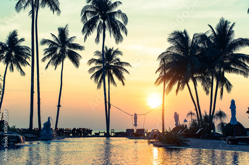 Beautiful sunset on a tropical sea coast with palm trees. © De Visu