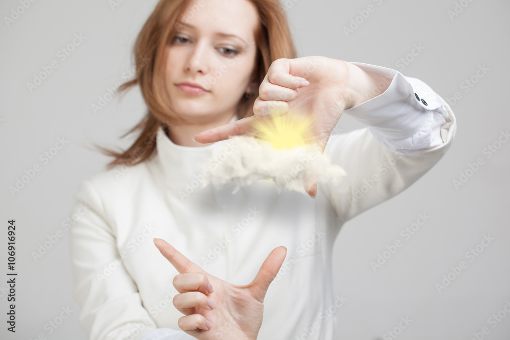 Young woman and sun shining out from behind the clouds, cloud computing or weather concept Young woman and sun shining out from behind the clouds, cloud computing or weather concept