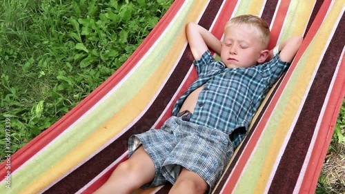 A wee blond lad chilling out in the hammock on summer afternoon