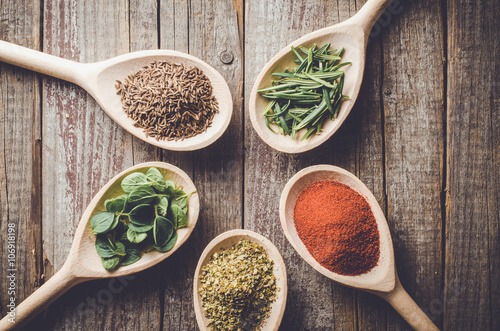 Fototapeta Naklejka Na Ścianę i Meble -  Aromatic herbs and spices on wooden spoons