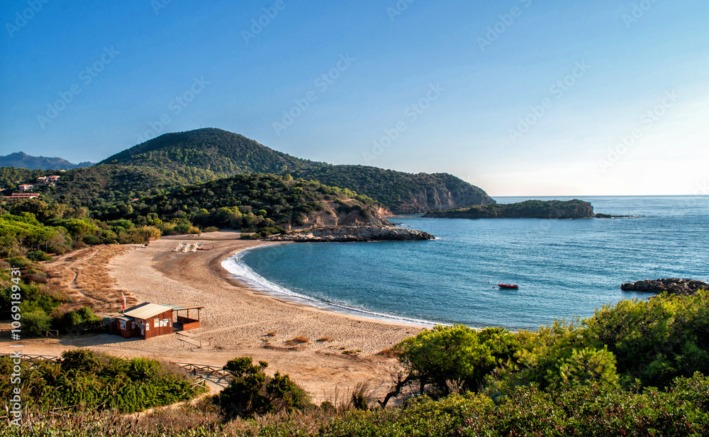 Sandy beach in a bay below the mountains on the island of Sardinia