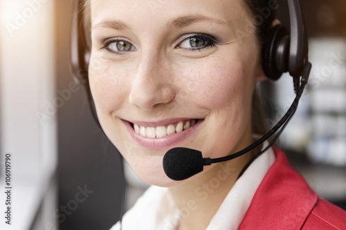 Close up of young businesswoman using telephone headset photo