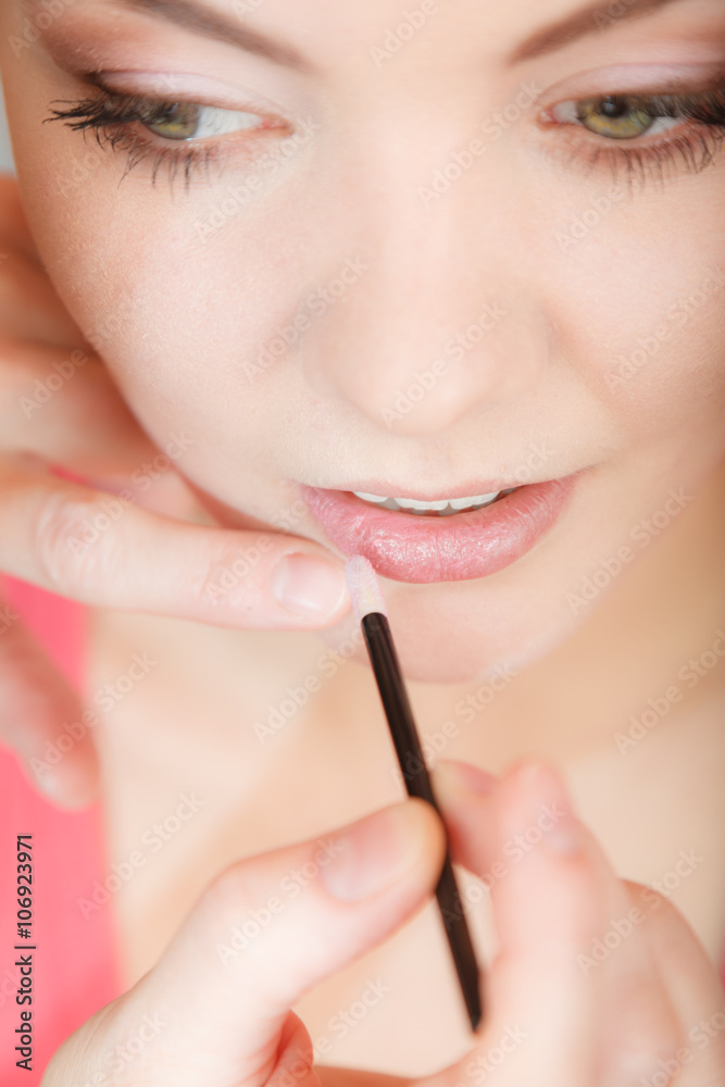Attractive woman applying lipstick. Make up.