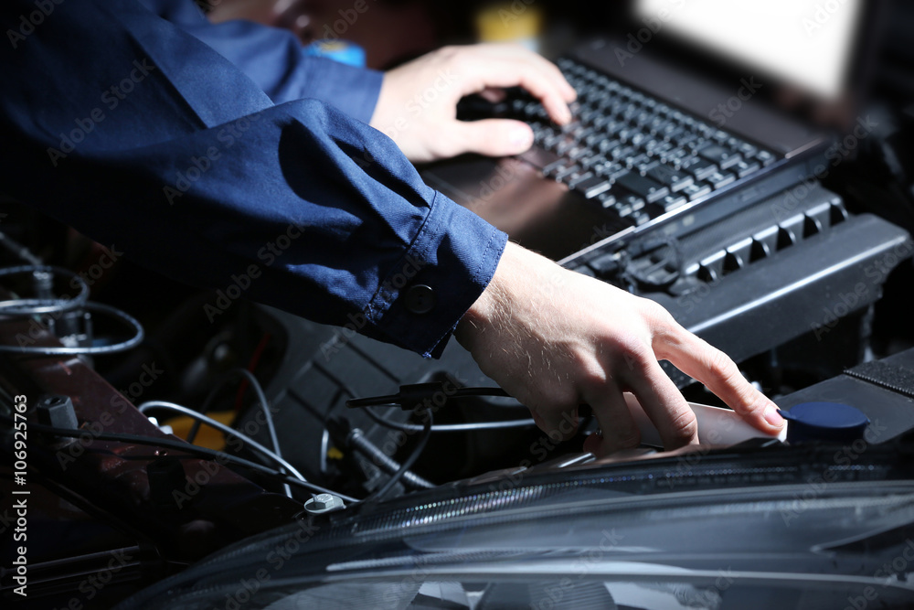 Professional auto mechanic working in repairing service, close-up. Car diagnostics concept Professional auto mechanic working in repairing service, close-up. Car diagnostics concept