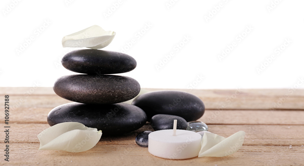 Spa stones with white petals and candle on white background Spa stones with white petals and candle on white background