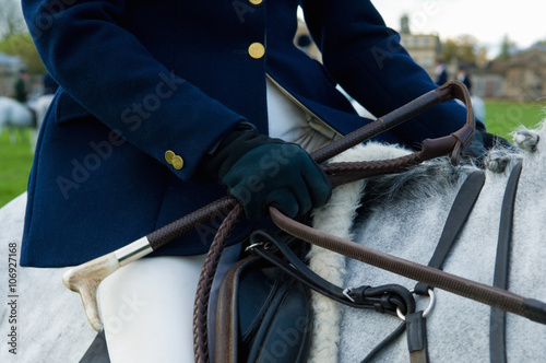 Close up cropped shot of mature woman riding grey horse