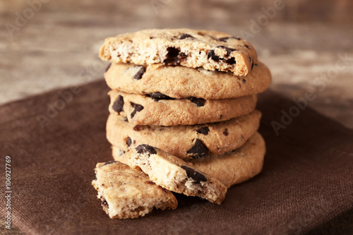 Quadro su tela Chocolate chip cookies on a brown napkin on wooden table