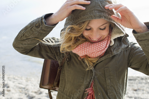 Woman all wrapped up on windy beach