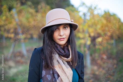 Spring and autumn portrait of cute young woman, posing with a hat, looking at the camera © Andphotography