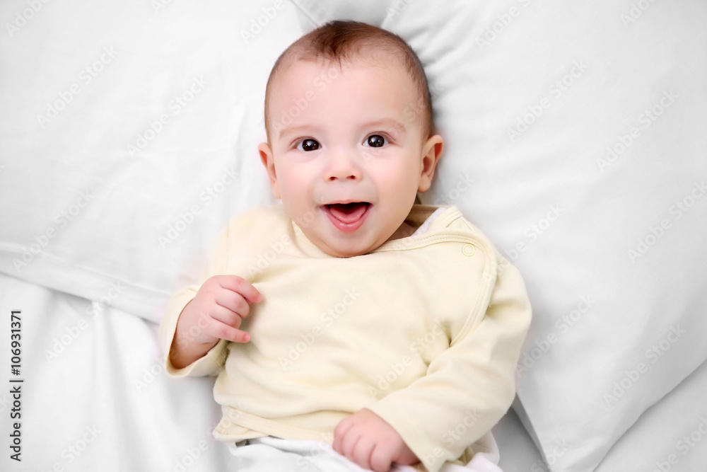 Loving baby lying on soft bed, close up Loving baby lying on soft bed, close up