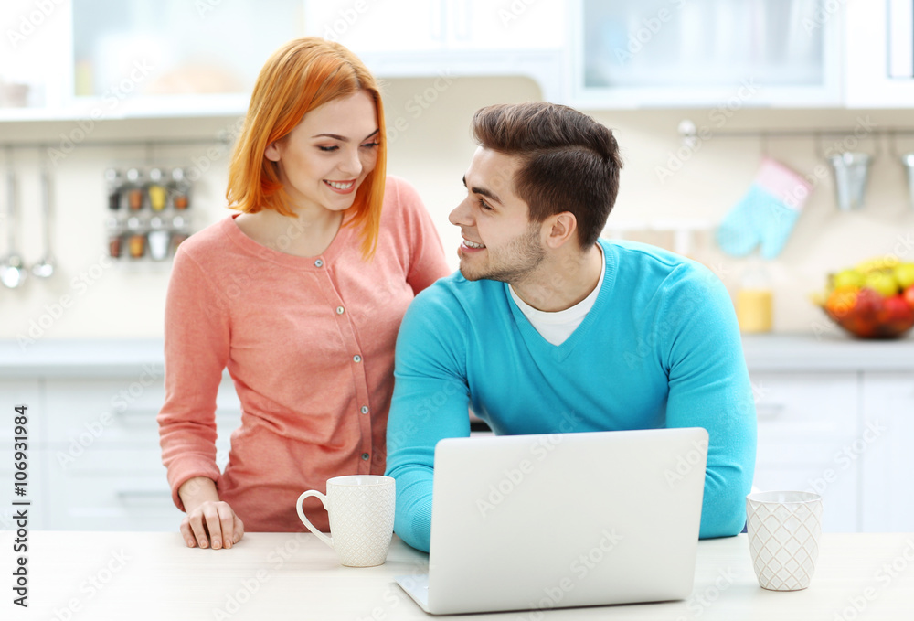 Young beautiful couple with cup of tea using laptop Young beautiful couple with cup of tea using laptop