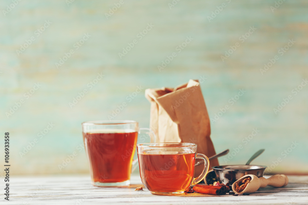 Glass cup of tea with spices on blurred background Glass cup of tea with spices on blurred background