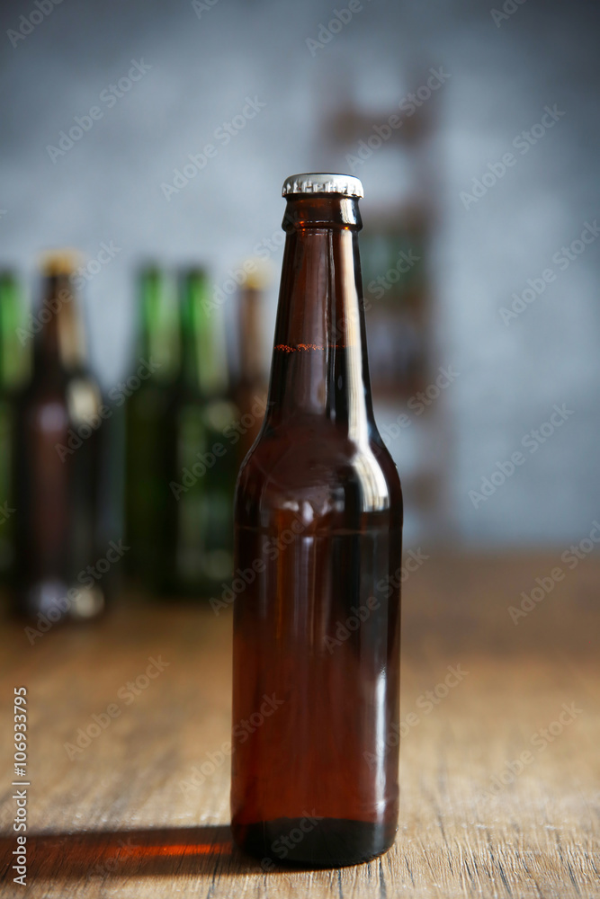 Brown glass bottle of beer on wooden table