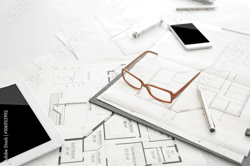Blueprints and glasses on table, closeup