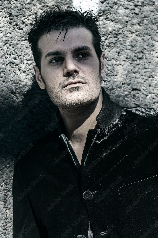 Obraz premium Handsome man portrait standing by a wall