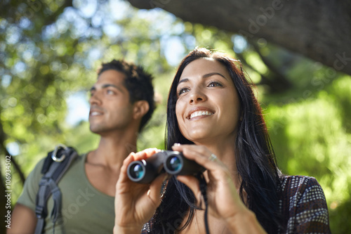 Couple with binoculars birdwatching in forest photo