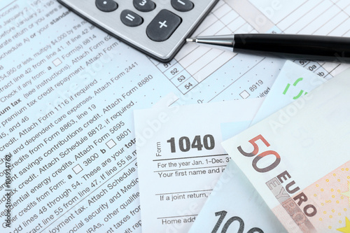 1040 Income Tax Form and euro bills, close up