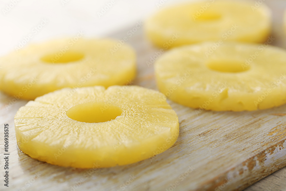 Rings of pineapple on wooden cutting board closeup