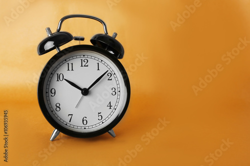 Alarm clock on brown background.