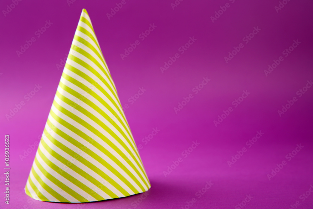 Striped Birthday hat on purple background Striped Birthday hat on purple background