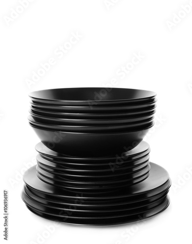 Stack of different black ceramic plates, isolated on white