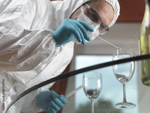 Forensic scientist using a DNA swab to take evidence from a glass at a scene of crime photo