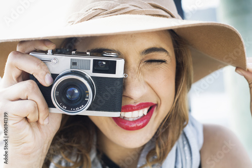 Close up of glamorous young woman holding up film camera