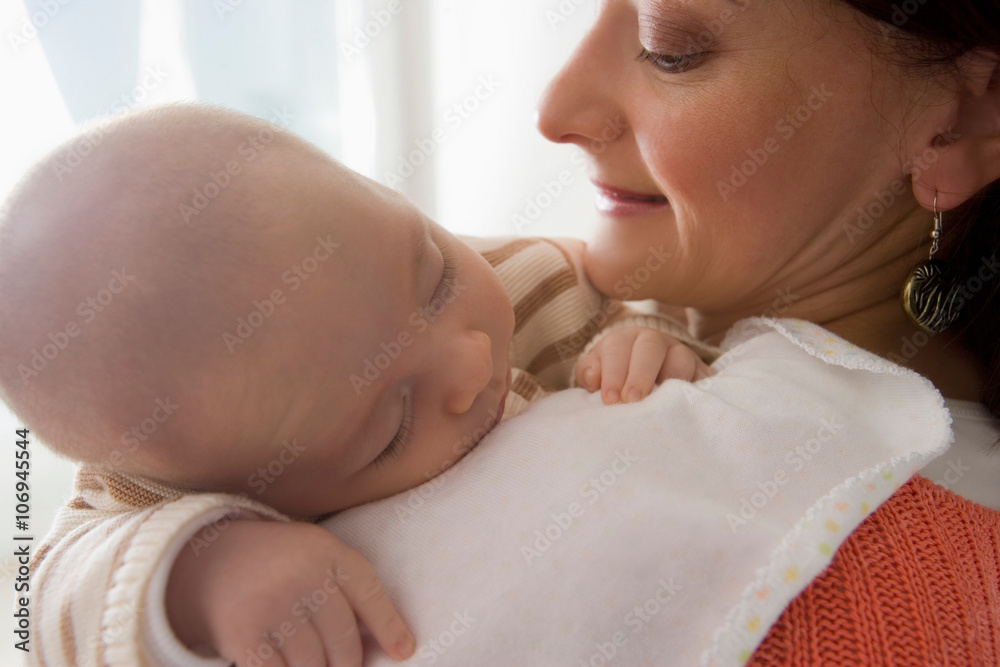 Baby boy sleeping on mother's shoulder, close up Baby boy sleeping on mother's shoulder, close up