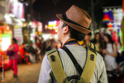 Young male backpacker walking in a famous street night market in Siem Reap, Cambodia