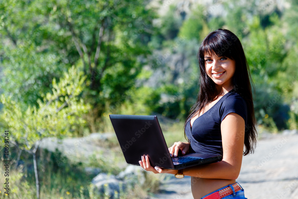 Beautiful smiling girl working on laptop outdoors. Beautiful smiling girl working on laptop outdoors.