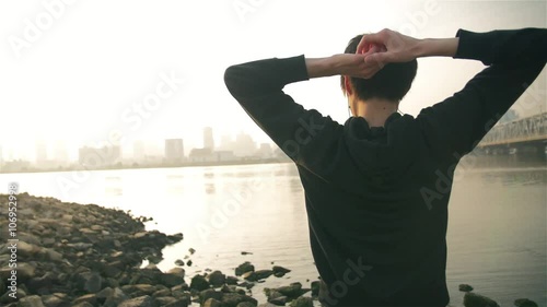 Inspirational Japanese fintness man warms down on at the river after training hard photo