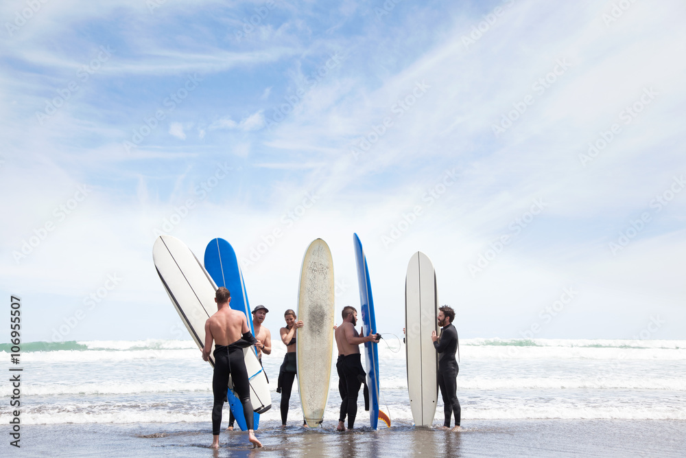 © Connect Images - Group of male and female surfer friends standing on beach with surf boards © Connect Images - Group of male and female surfer friends standing on beach with surf boards