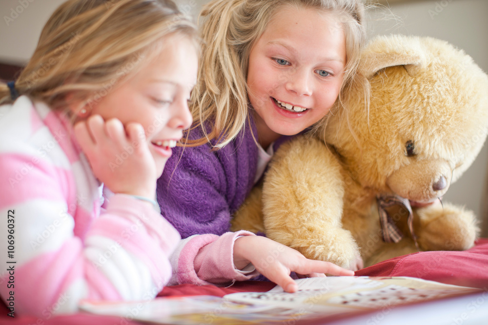 Sisters and teddy bear reading storybook Sisters and teddy bear reading storybook