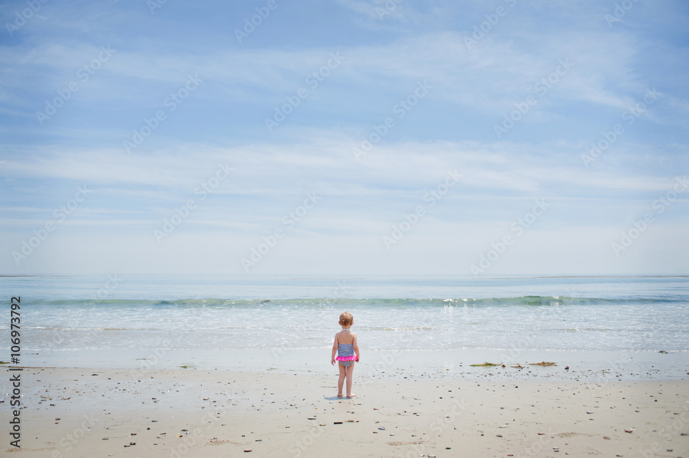 Apprehensive female toddler watching the sea Apprehensive female toddler watching the sea