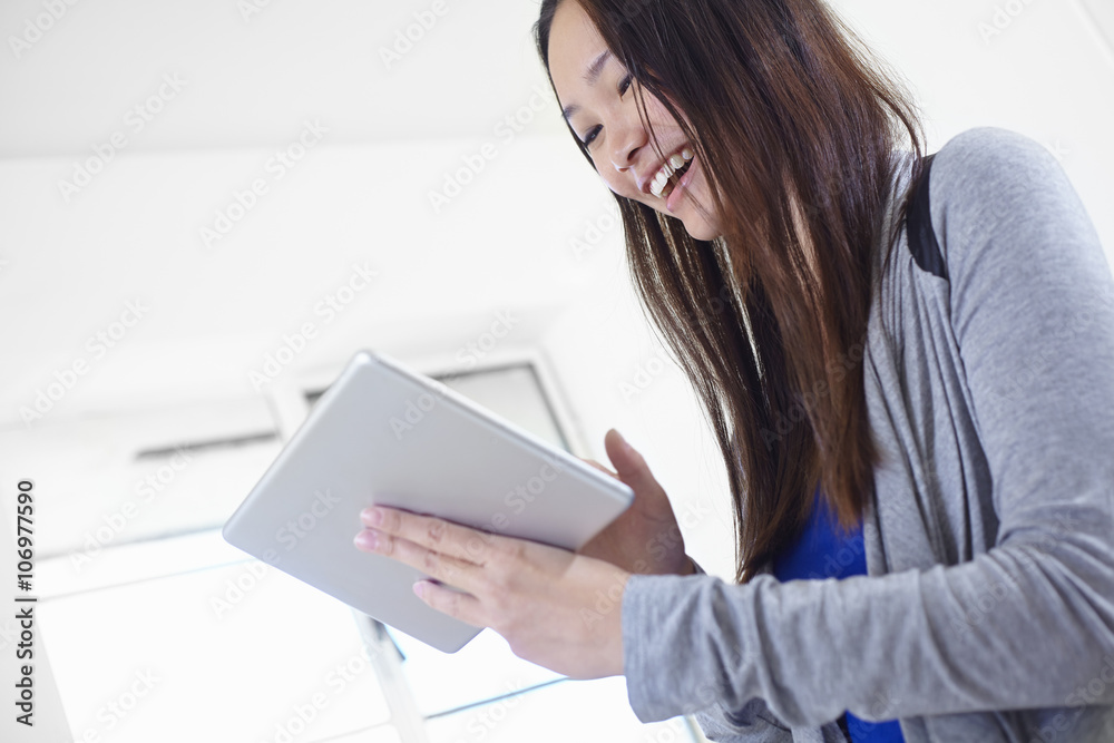 Young woman in kitchen using digital tablet