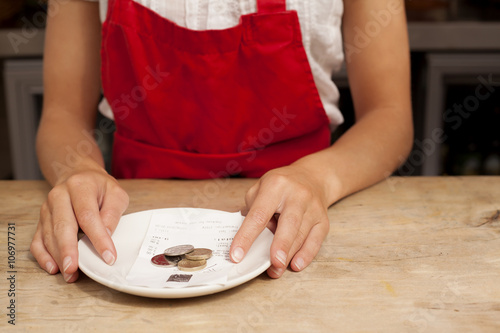 Close up of waitress with bill and gratuity at kitchen counter