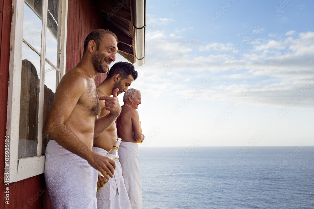 Three male friends standing outside sauna enjoying beer Stock Photo | Adobe  Stock