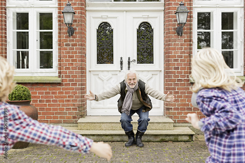 Grandfather welcoming grandchildren with arms open