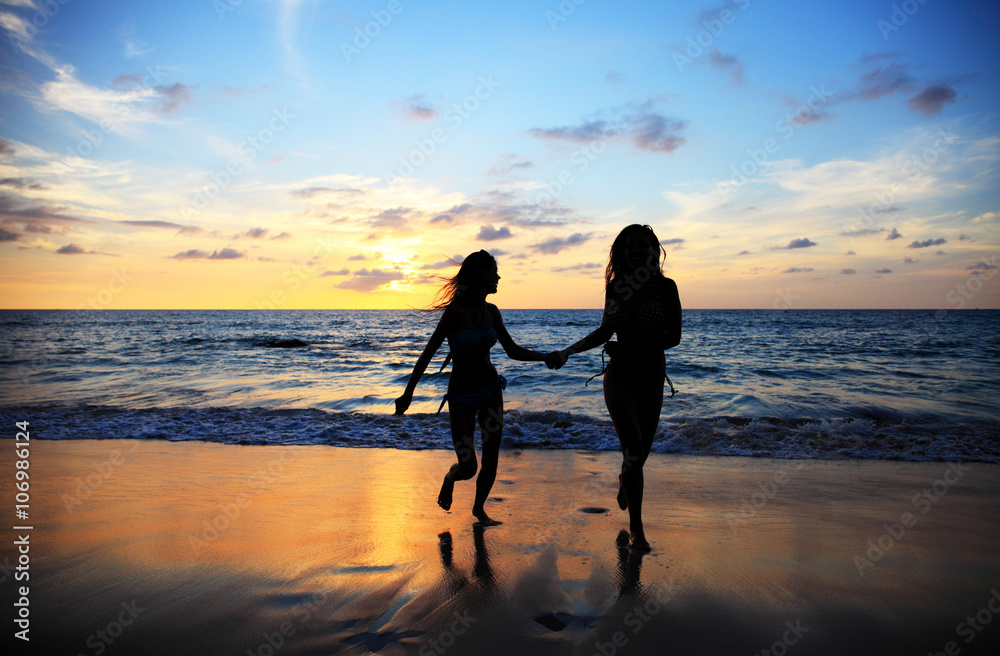 Women walking on sunset beach