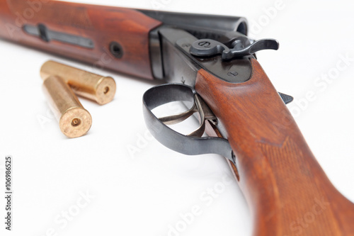 Opened double-barrelled hunting gun with bullets isolated on white