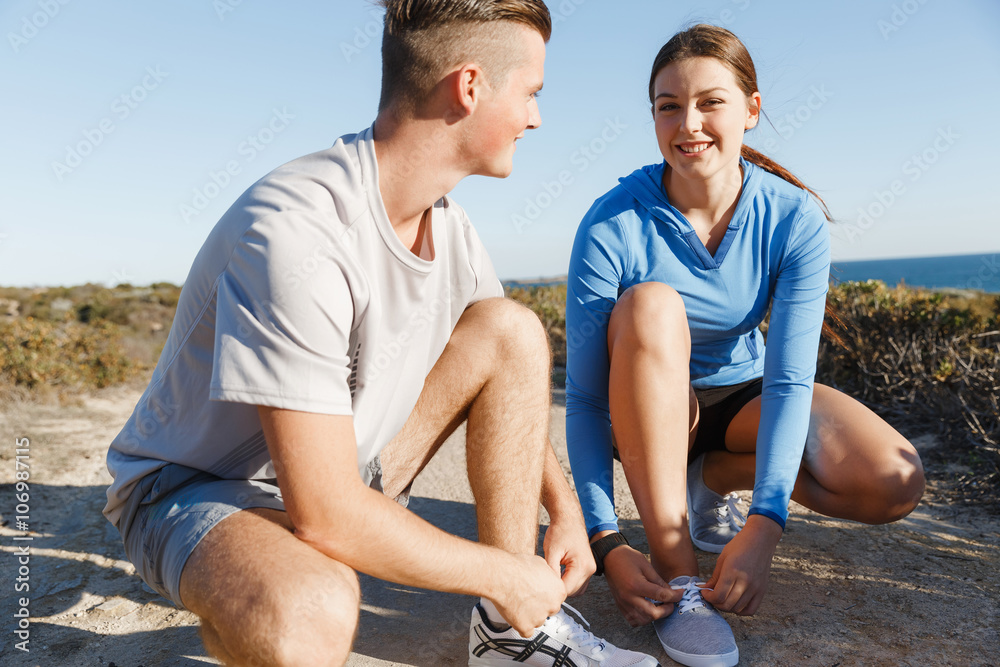 Couple of runners lace their shoes and prepare to jogging