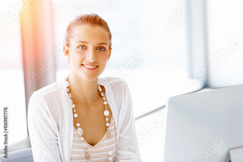 Attractive office worker sitting at desk Free Download Attractive office worker sitting at desk - GFXLoad