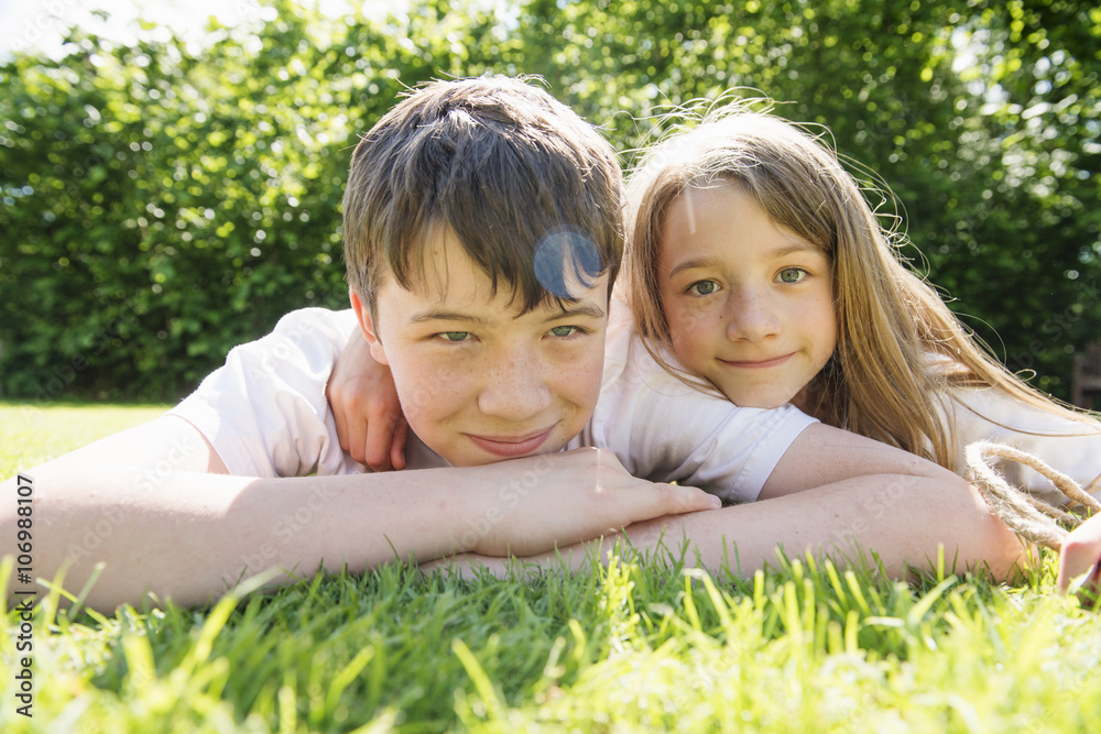 Portrait of brother and sister lying on grass Portrait of brother and sister lying on grass