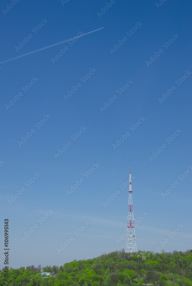 Obraz premium The Television Tower on hill and airplane in sky