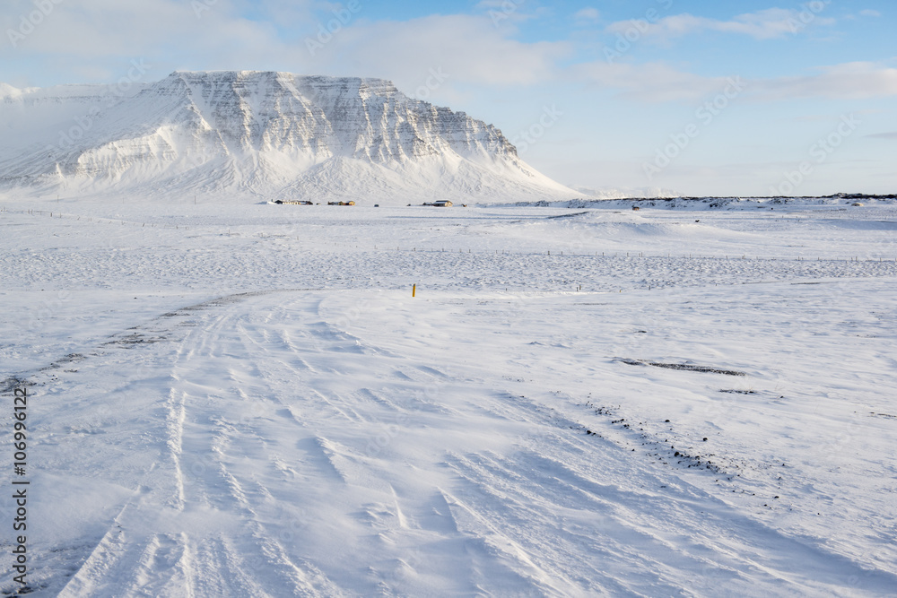 Winter landscape with mountain, a lot of snow and small farm houses, Iceland