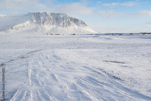 Winter landscape with mountain, a lot of snow and small farm houses, Iceland