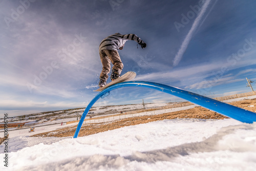 Photography Snowboarder sliding on a rail
